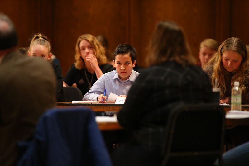  Boys sits a desk at the regional spelling bee contest
